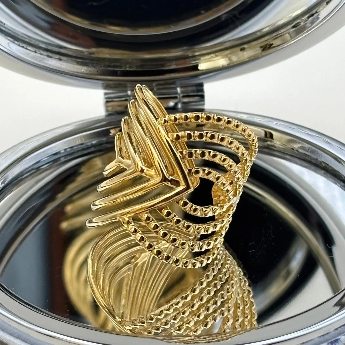 Bague dorée ajustable avec motifs géométriques en forme de volutes 