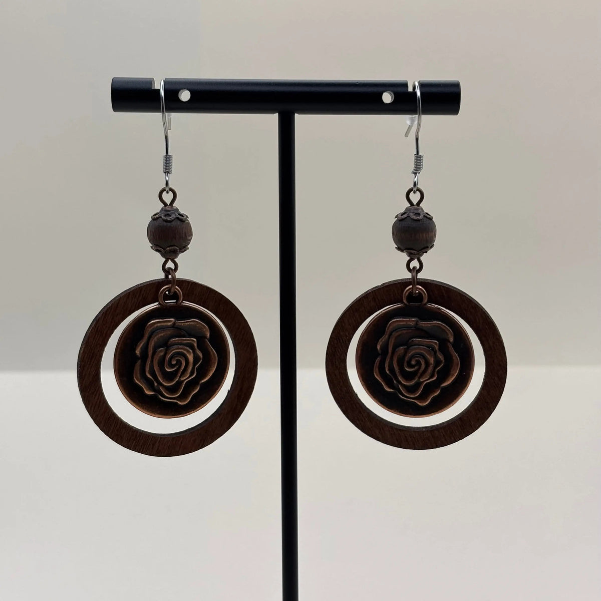 Boucle d'oreille en métal marron avec cercle et motif d'une fleur de rose