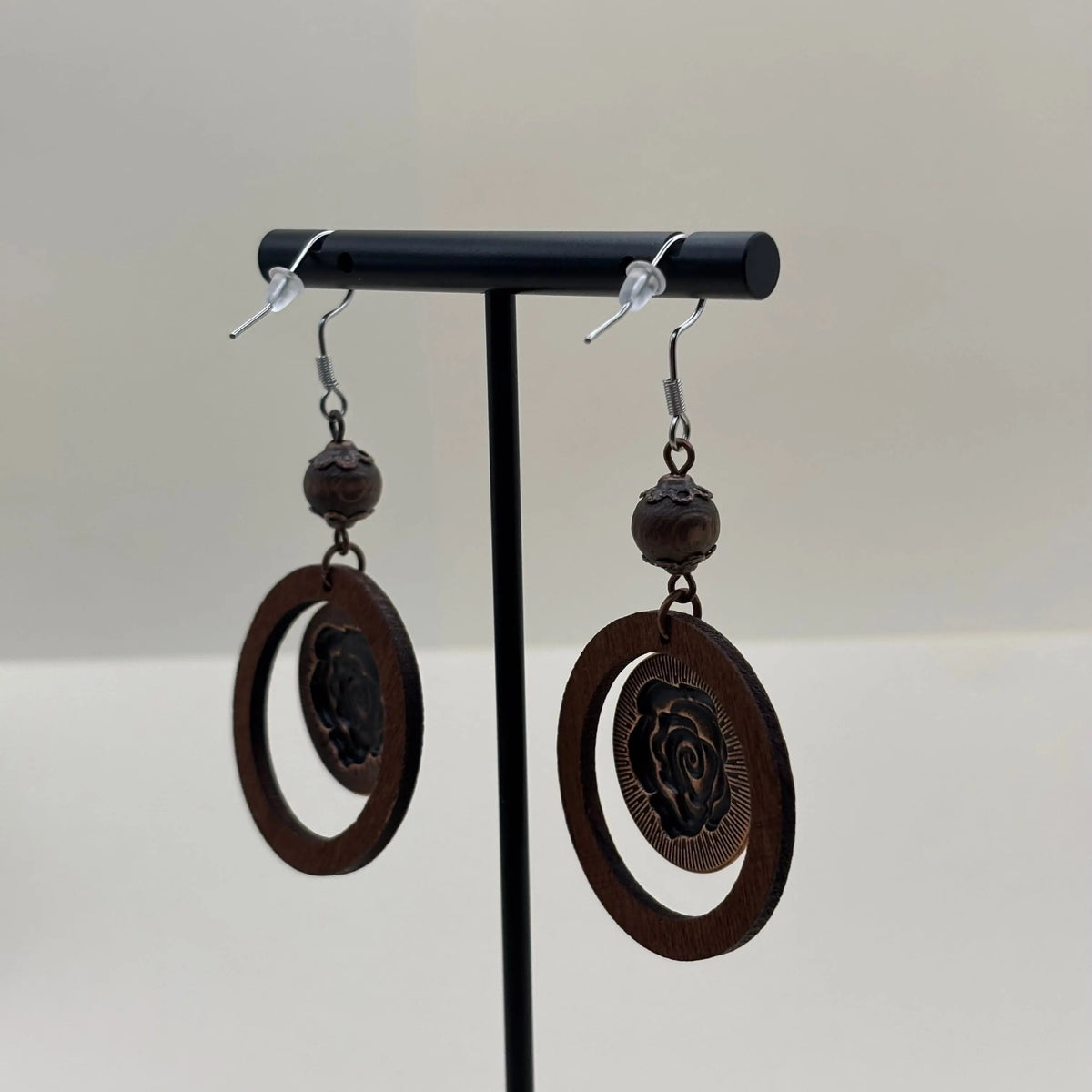 Des boucle d'oreille en métal marron avec cercle et motif d'une fleur de rose