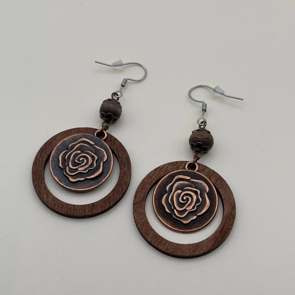 Une paire de boucles d'oreille en métal marron avec cercle et motif d'une fleur de rose