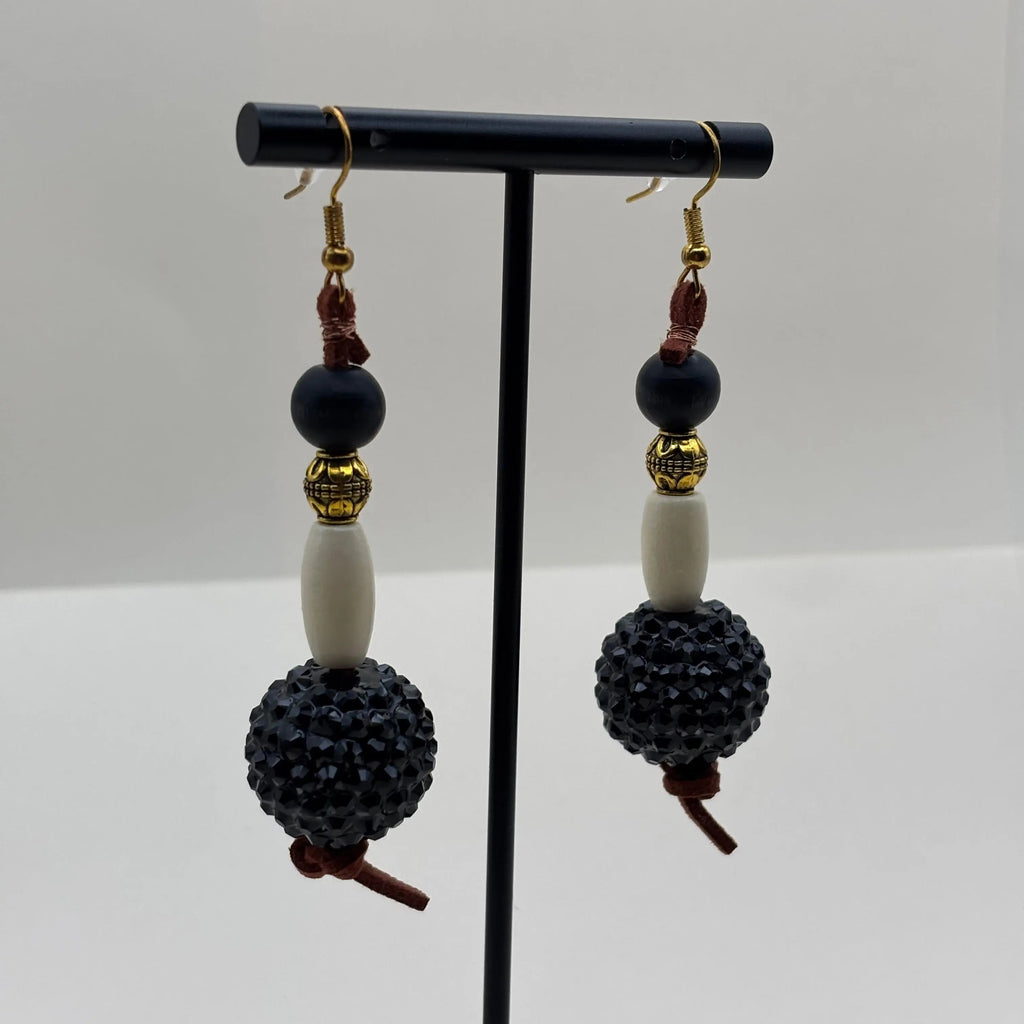 Boucles d'oreilles pendantes dorées, grosse perle noire et perle allongée blanche 