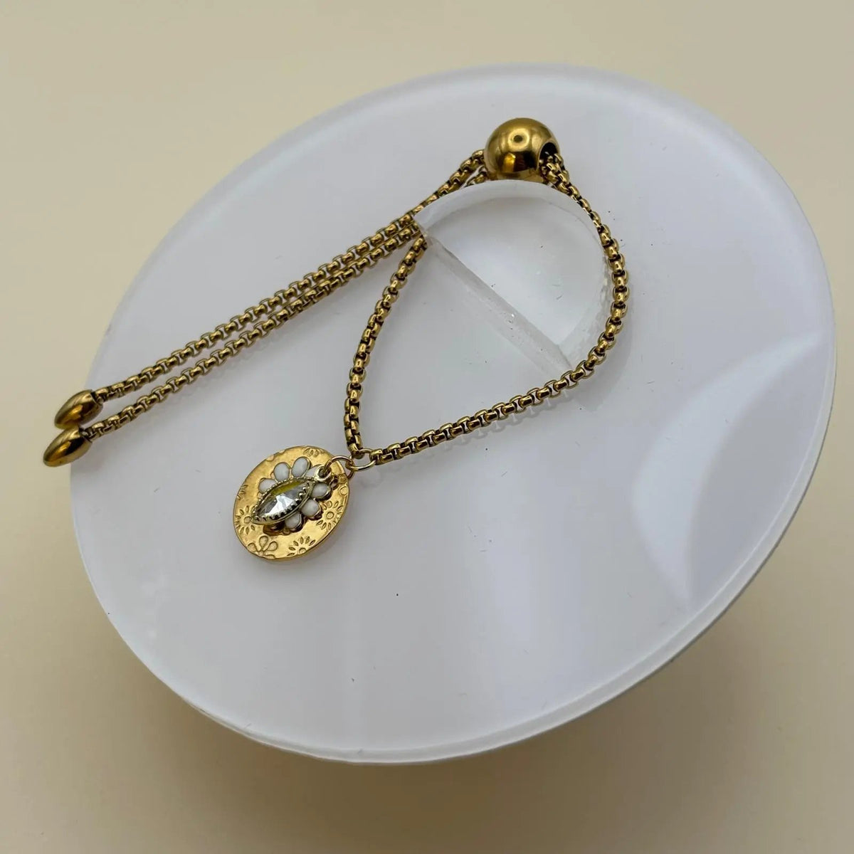 Bracelet de couleur doréeavec perle Swarovski et breloque marguerite pastille en forme de fleur en acier inoxydable sur le site internet prêtes à briller