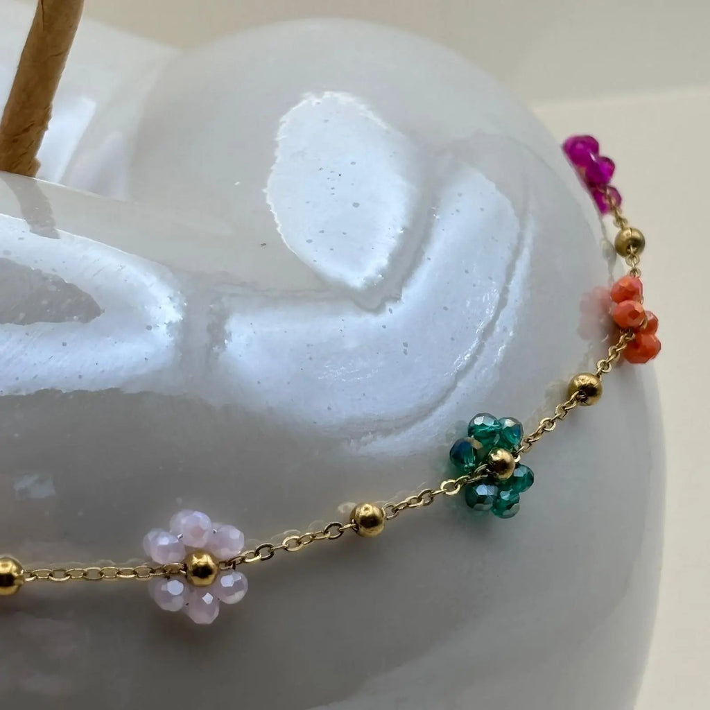 Un collier fantaisie avec des fleurs multicolores sur chainette dorée en acier inoxydable