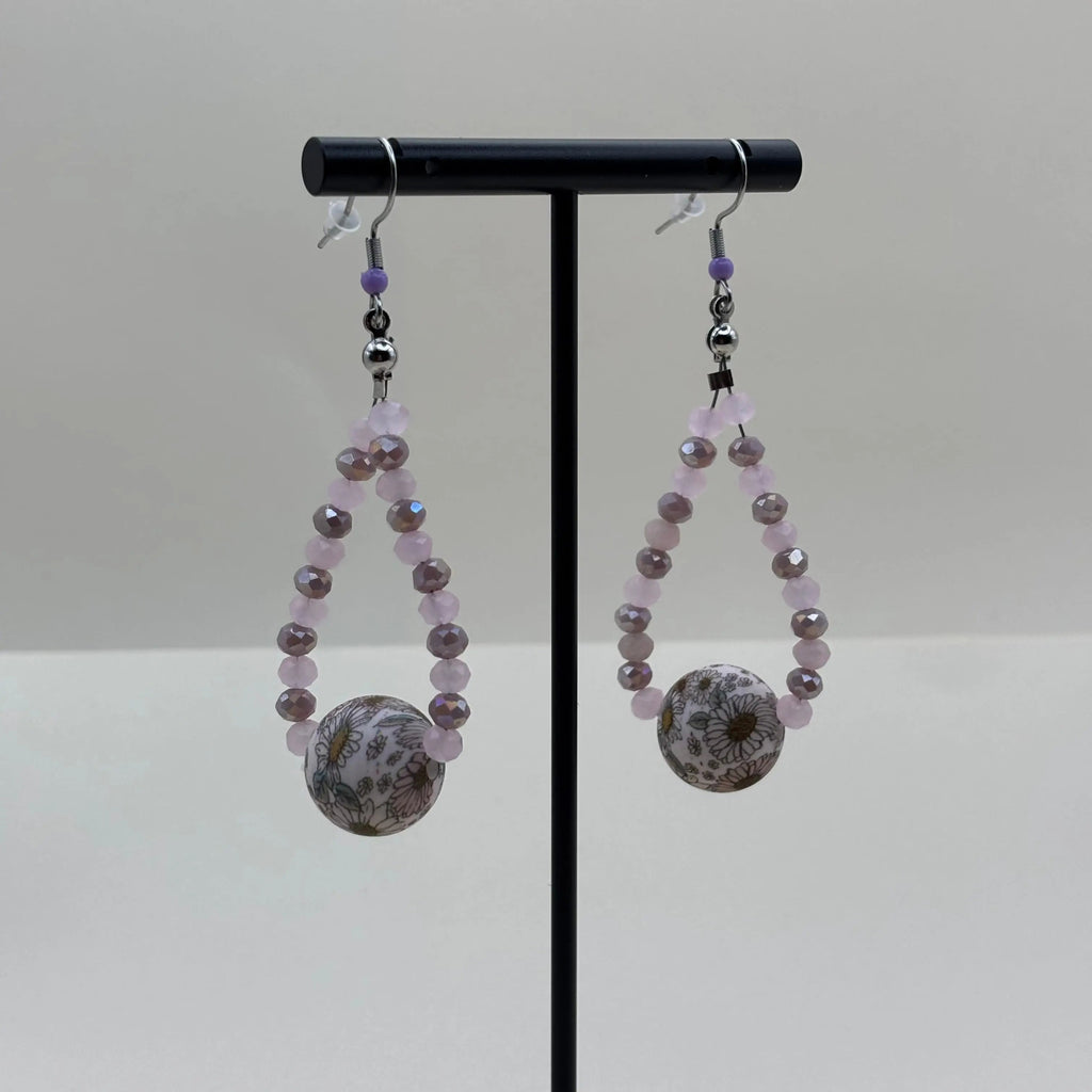Boucles d'oreilles pendentif avec des petites perles mauves et une grosse perle fleurie 