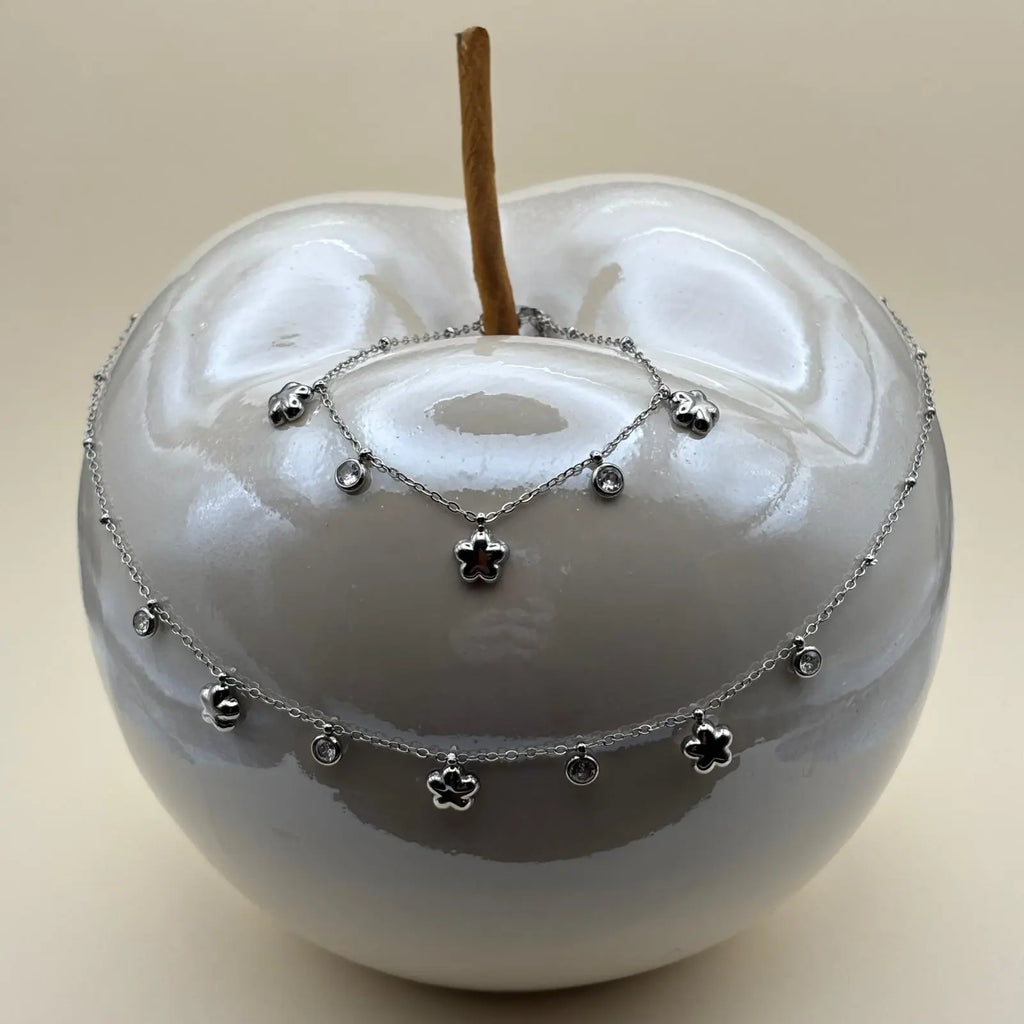 Collier argenté avec de fins maillons et des breloques en forme d'étoile et de strass