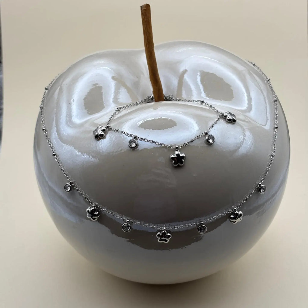 Collier argenté avec de très fins maillons et des breloques en forme d'étoile et de strass