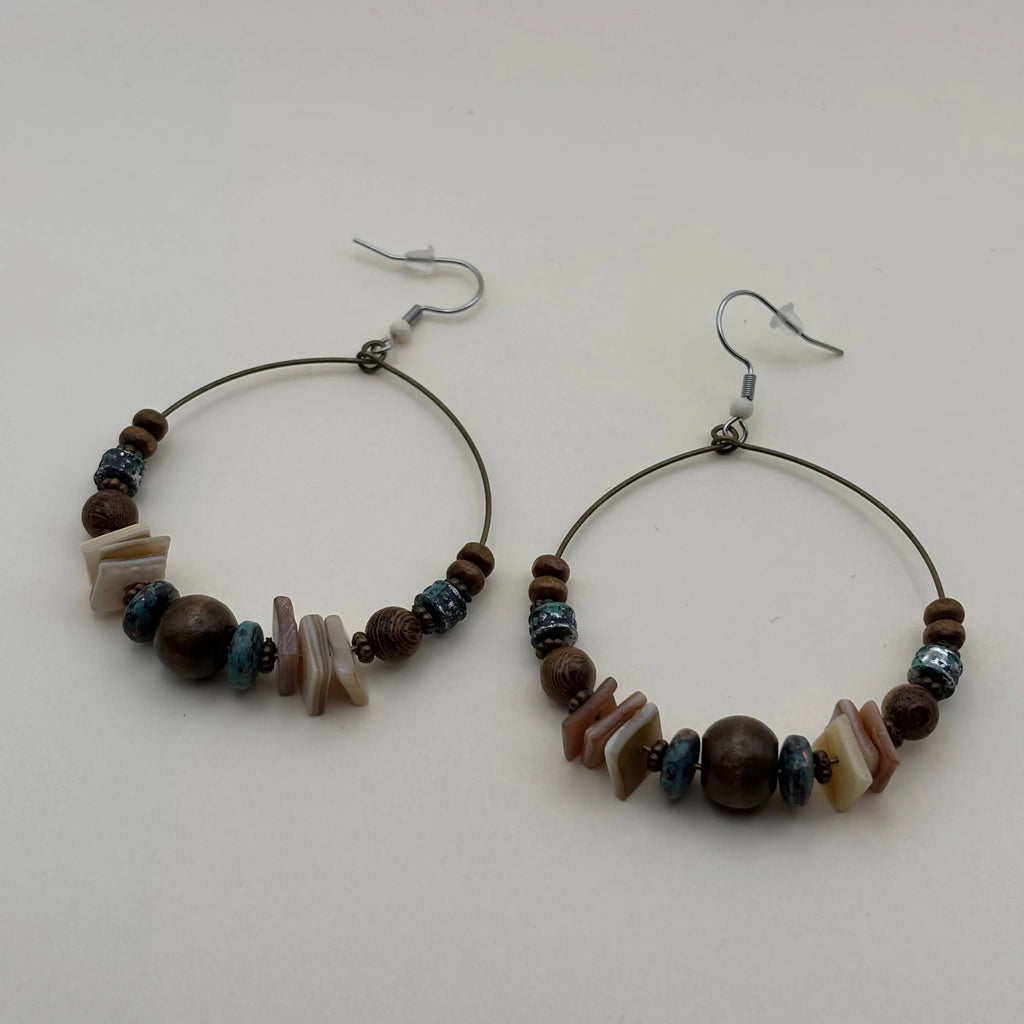 Une paire de boucles d'oreilles créoles avec des perles ronde marron et plates blanches