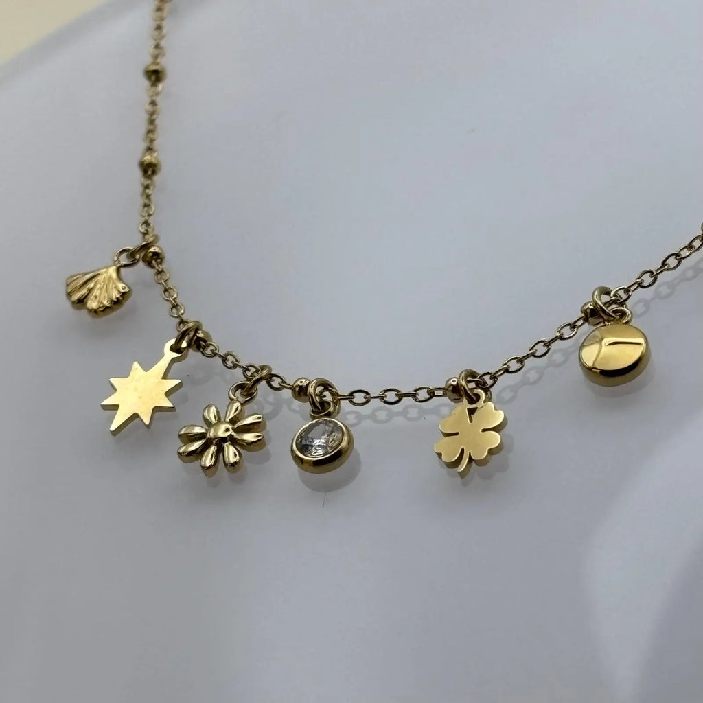 Bracelet doré à petits maillons avec des breloques en forme étoile fleurs trèfles coquillages et brillants en acier inoxydable 