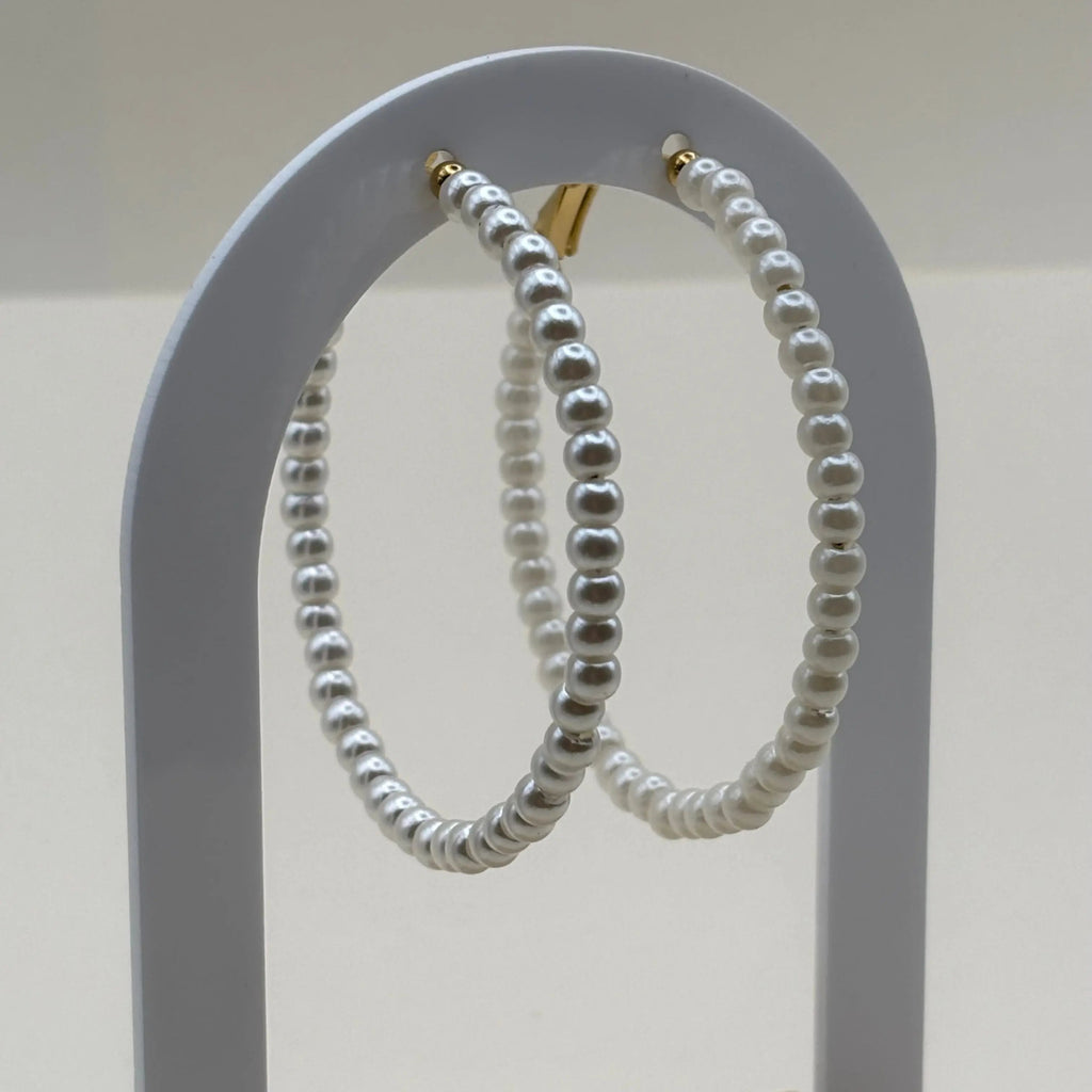 Des boucles d'oreilles créoles en perles acryliques blanches tour en acier inoxydable