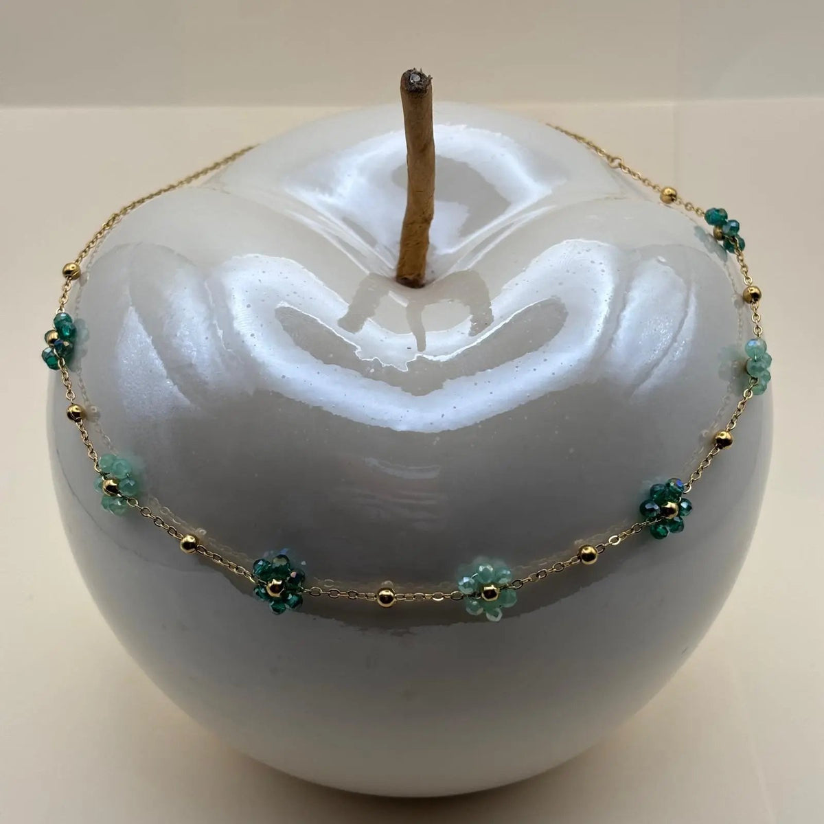 Collier fantaisie avec une chaine dorée à petits maillons et des fleurs colorées vertes la chaine est en acier inoxydable 