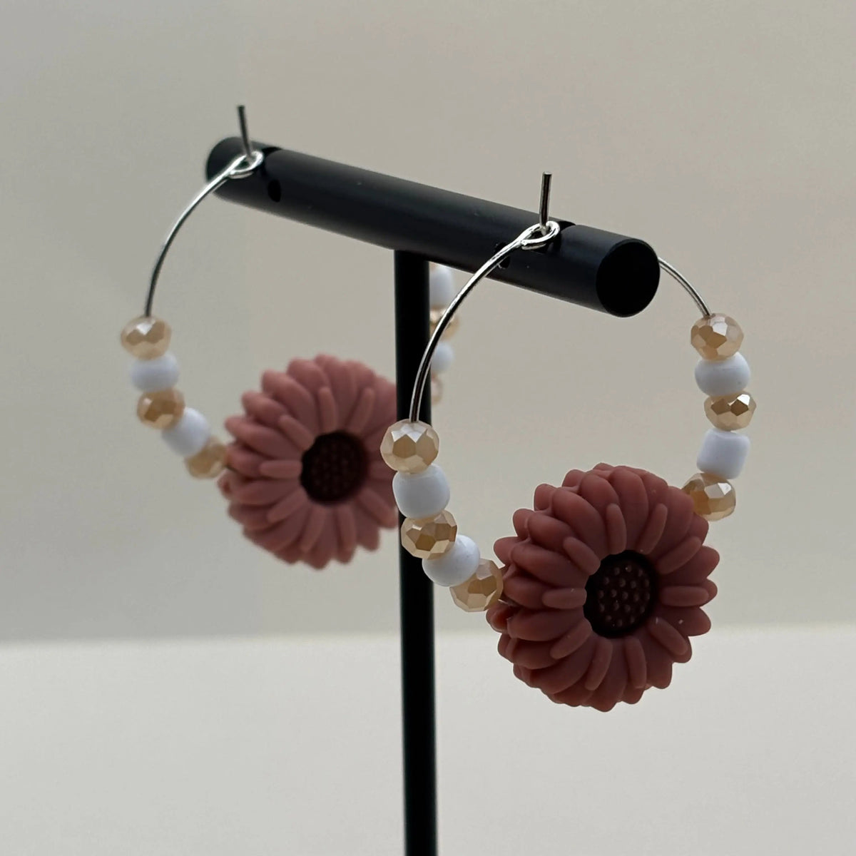 Une paire de boucles d'oreilles créole avec perles et fleur rose