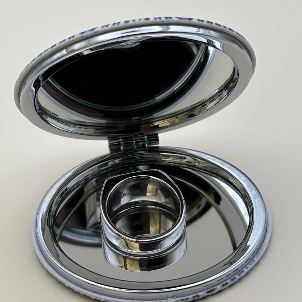 Chevalière de couleur argentée de forme rectangulaire avec un strass sur le dessus et des motifs ciselées