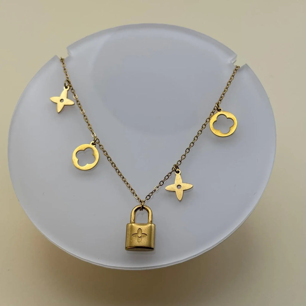Bracelet doré avec des breloques cadenas trèfles et étoiles en acier inoxydable