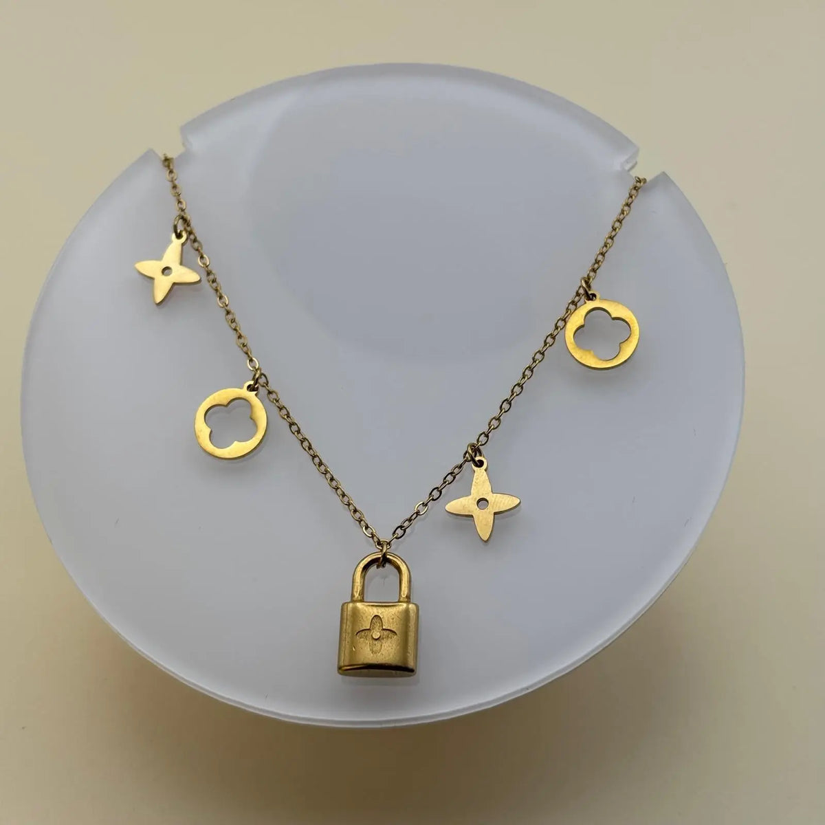 Bracelet doré avec des breloques cadenas trèfles et étoiles en acier inoxydable