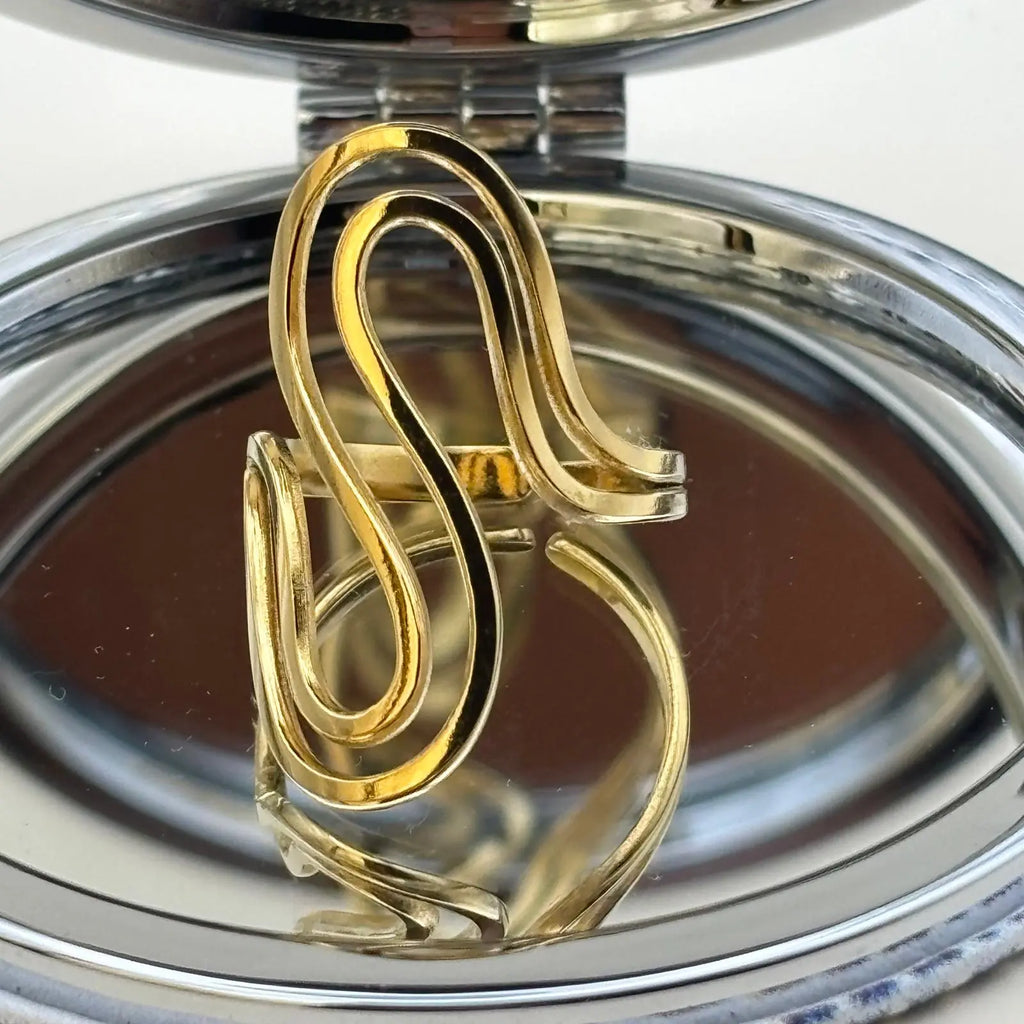 Bague de couleur dorée réglable avec des formes de volutes