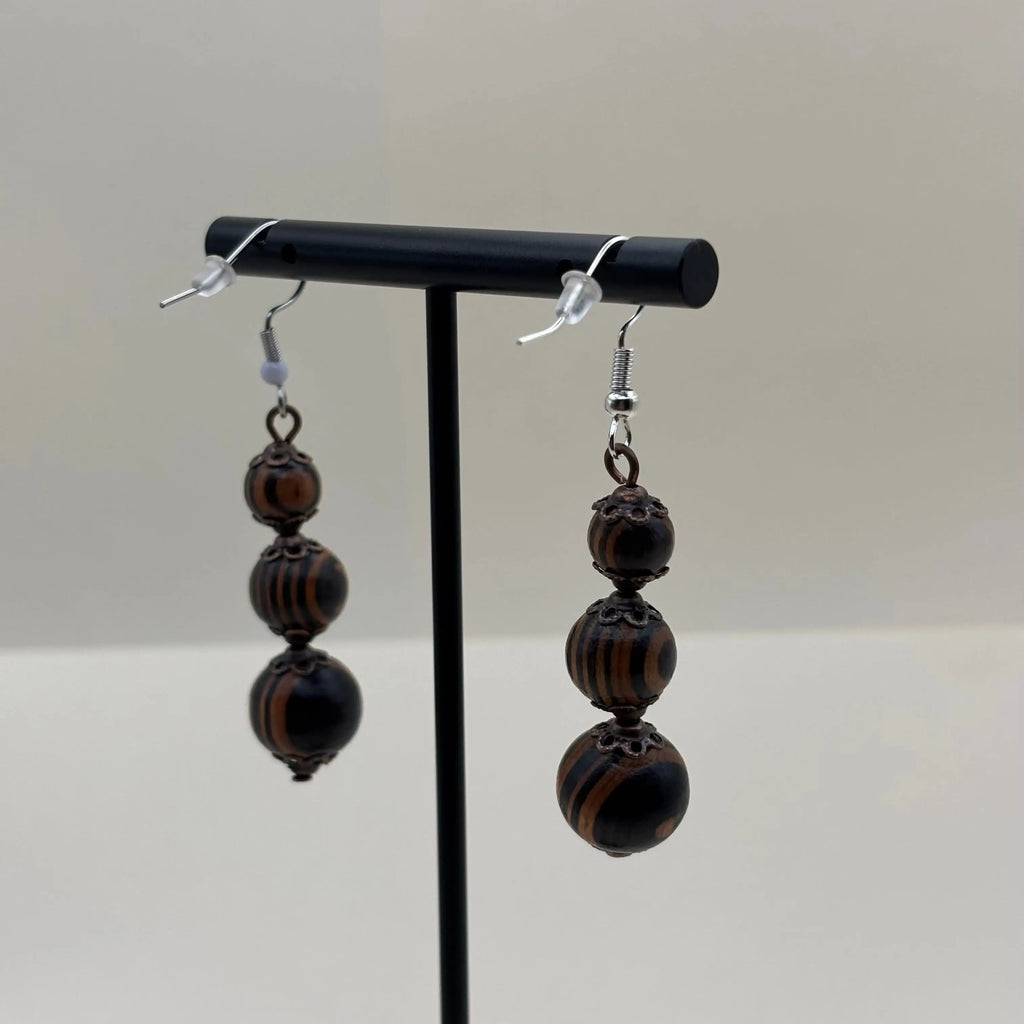Des boucles d'oreilles artisanales crochet argenté en acier inoxydable et trois perles marbrées marron