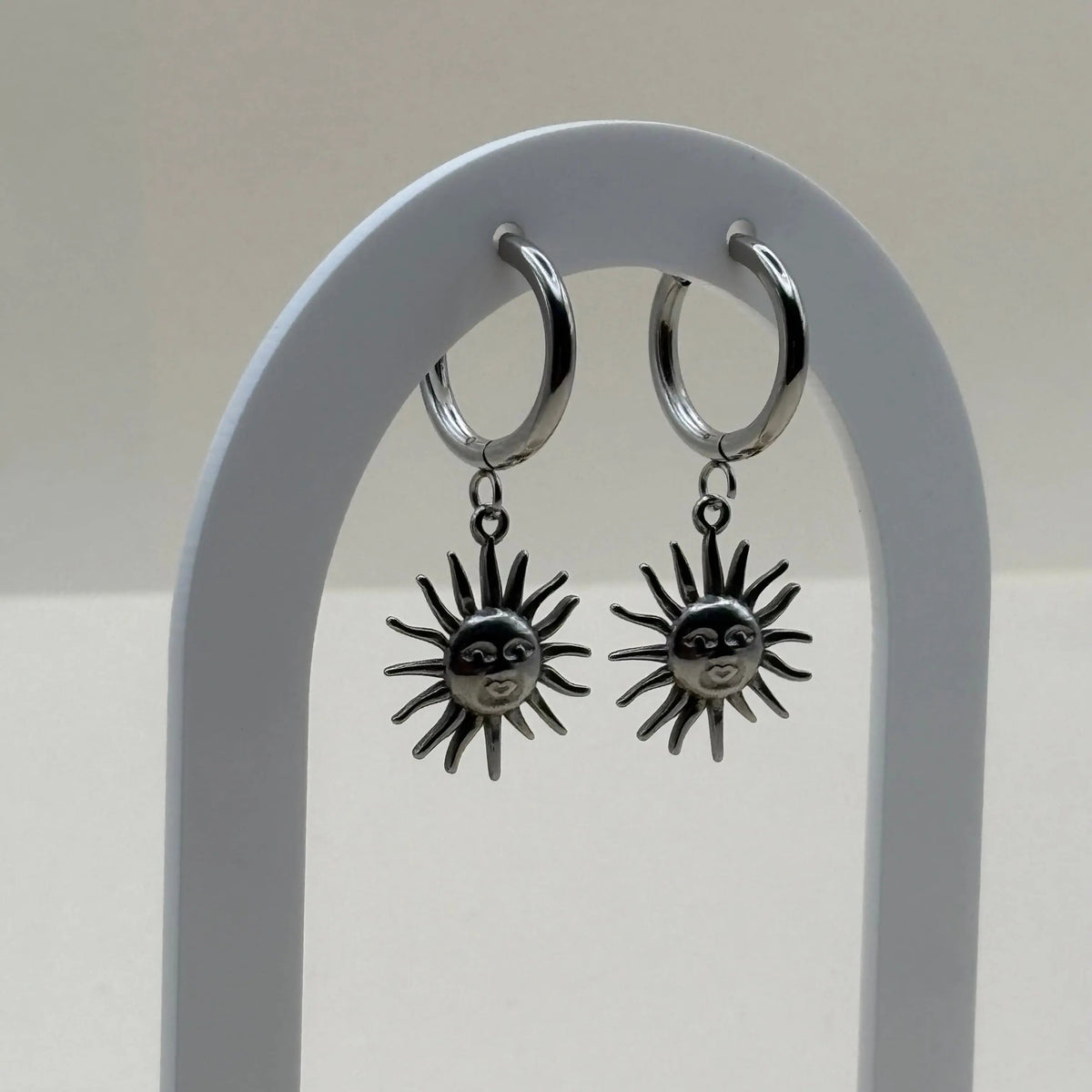 Boucles d'oreilles argentées petites créoles avec visage dans un soleil  en acier inoxydable