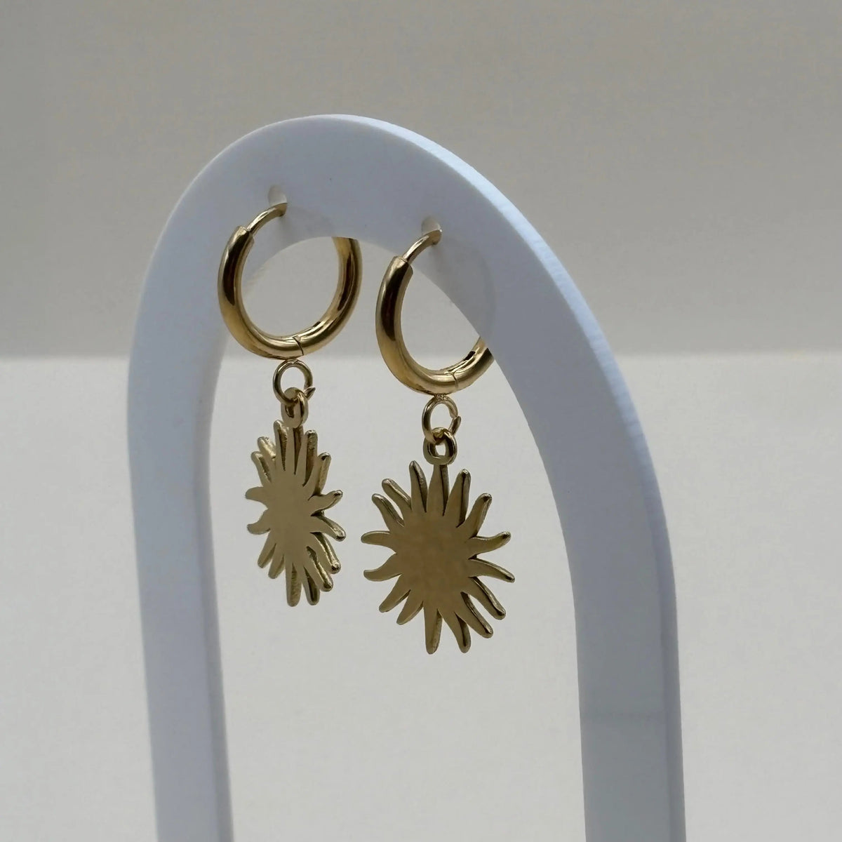 Une paire de boucles d'oreilles dorées petites créoles avec visage dans un soleil  en acier inoxydable