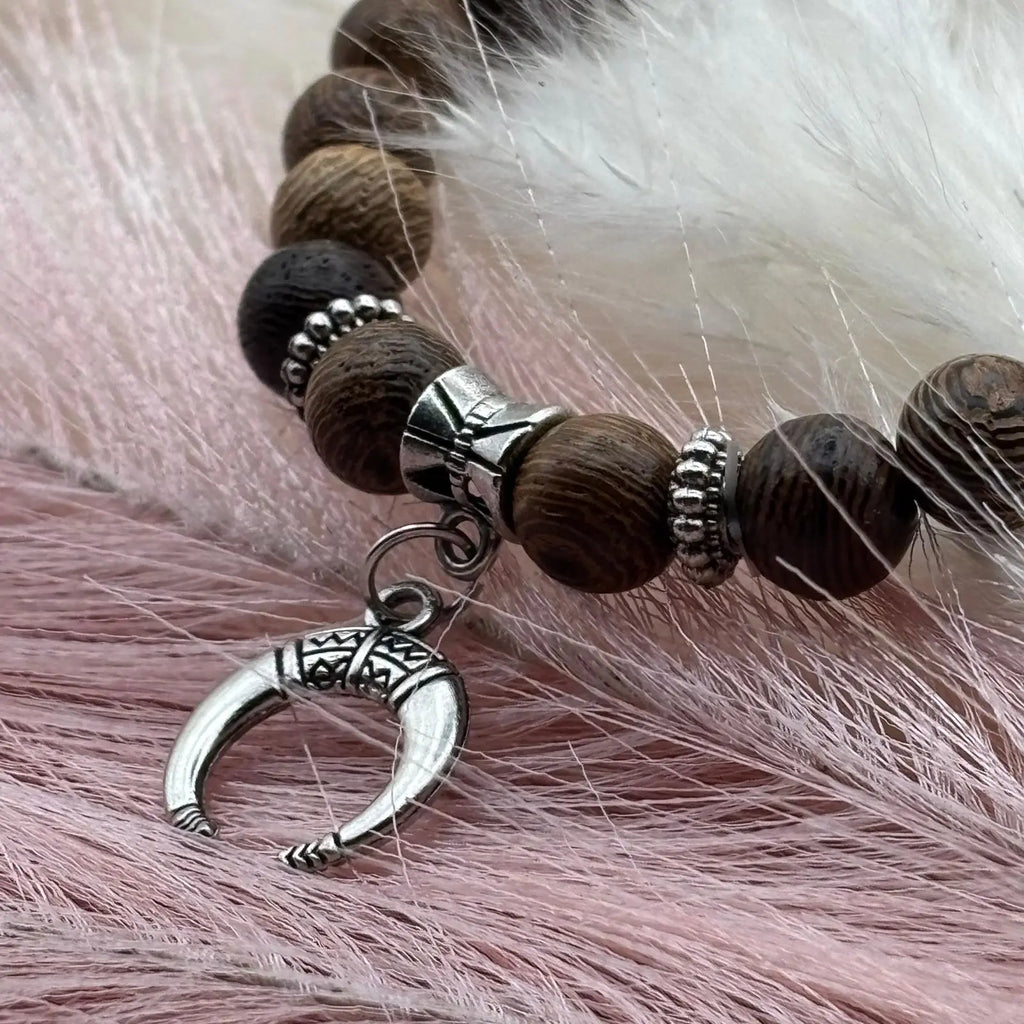 Bracelet en perles artisanal avec une breloque lune argentée et des perles en bois sur élastique