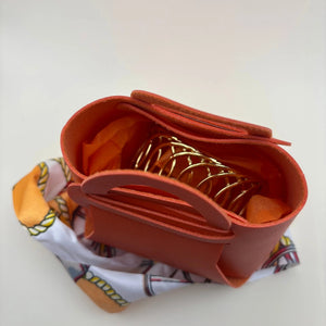 Un emballage en forme de sac à main orange en simili cuir