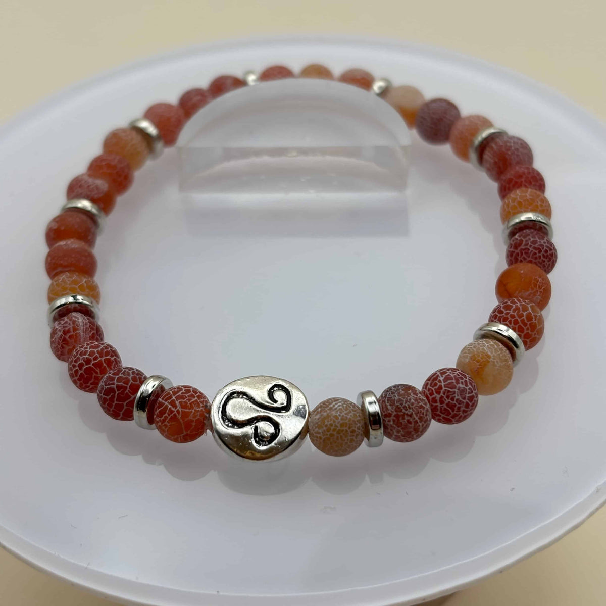 Un beau bracelet en perles sur élastique avec perles en porcelaine et en verre et médaillon avec le signe du lion