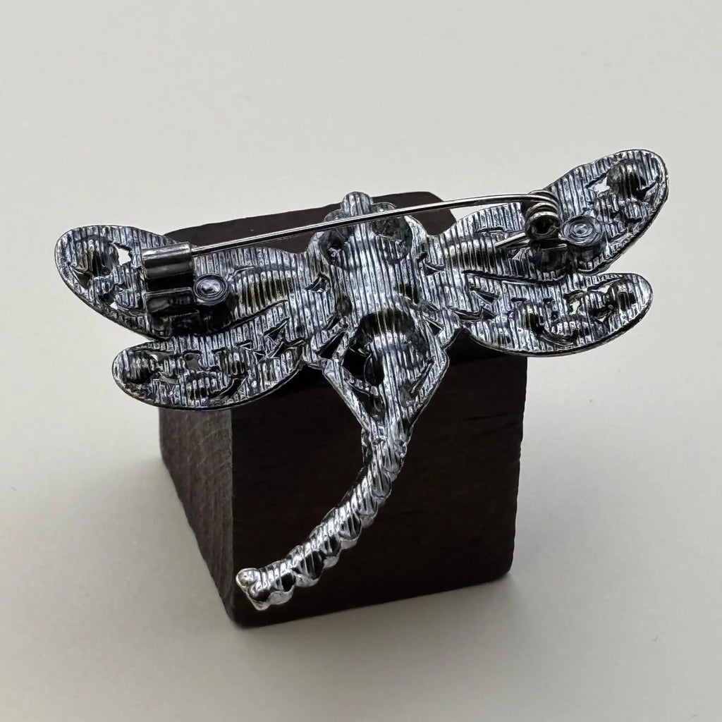 vue de l'arrière d'une broche en forme de libellule avec des strass noir et violet