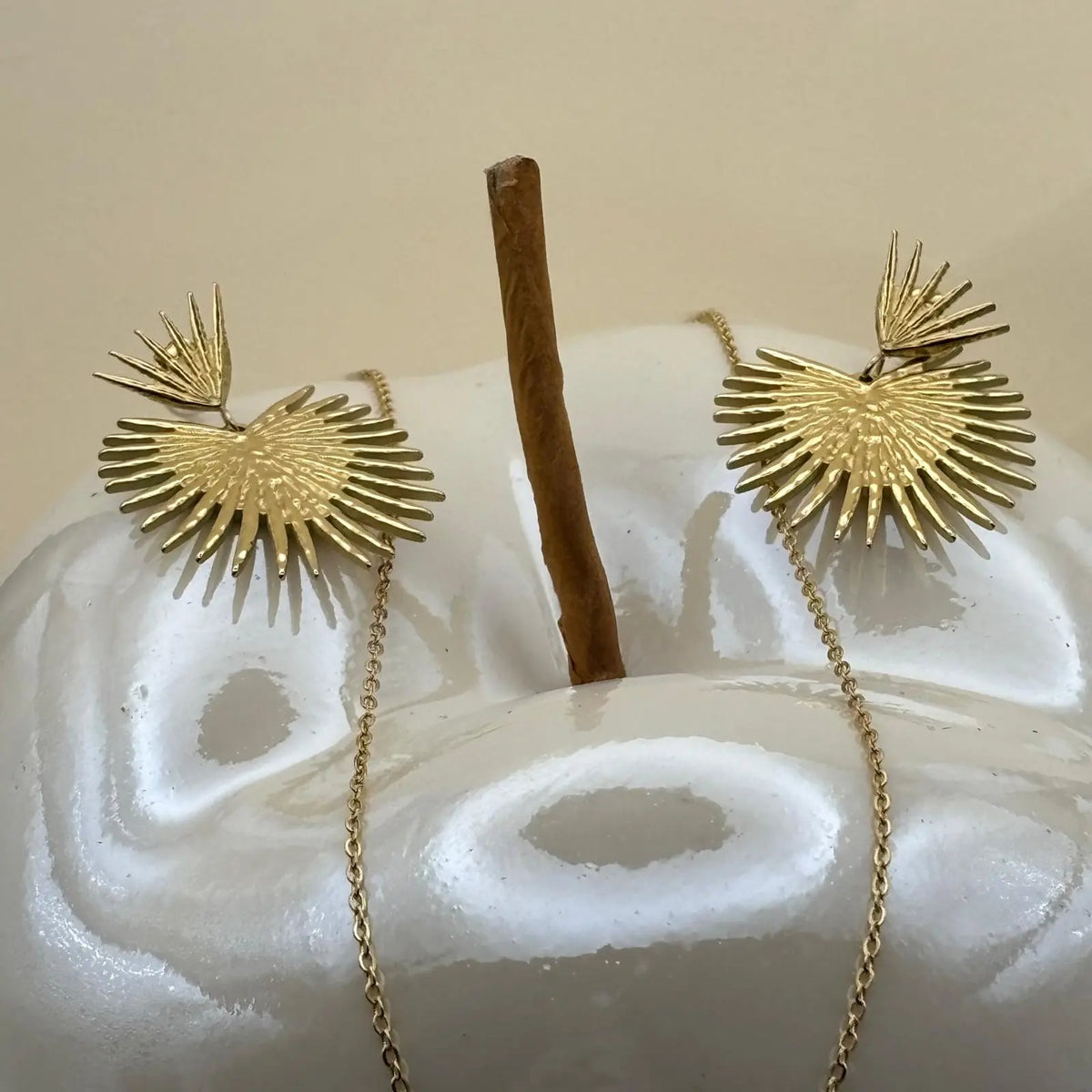 Collier et boucles d'oreilles dorées avec motif soleil éclatant