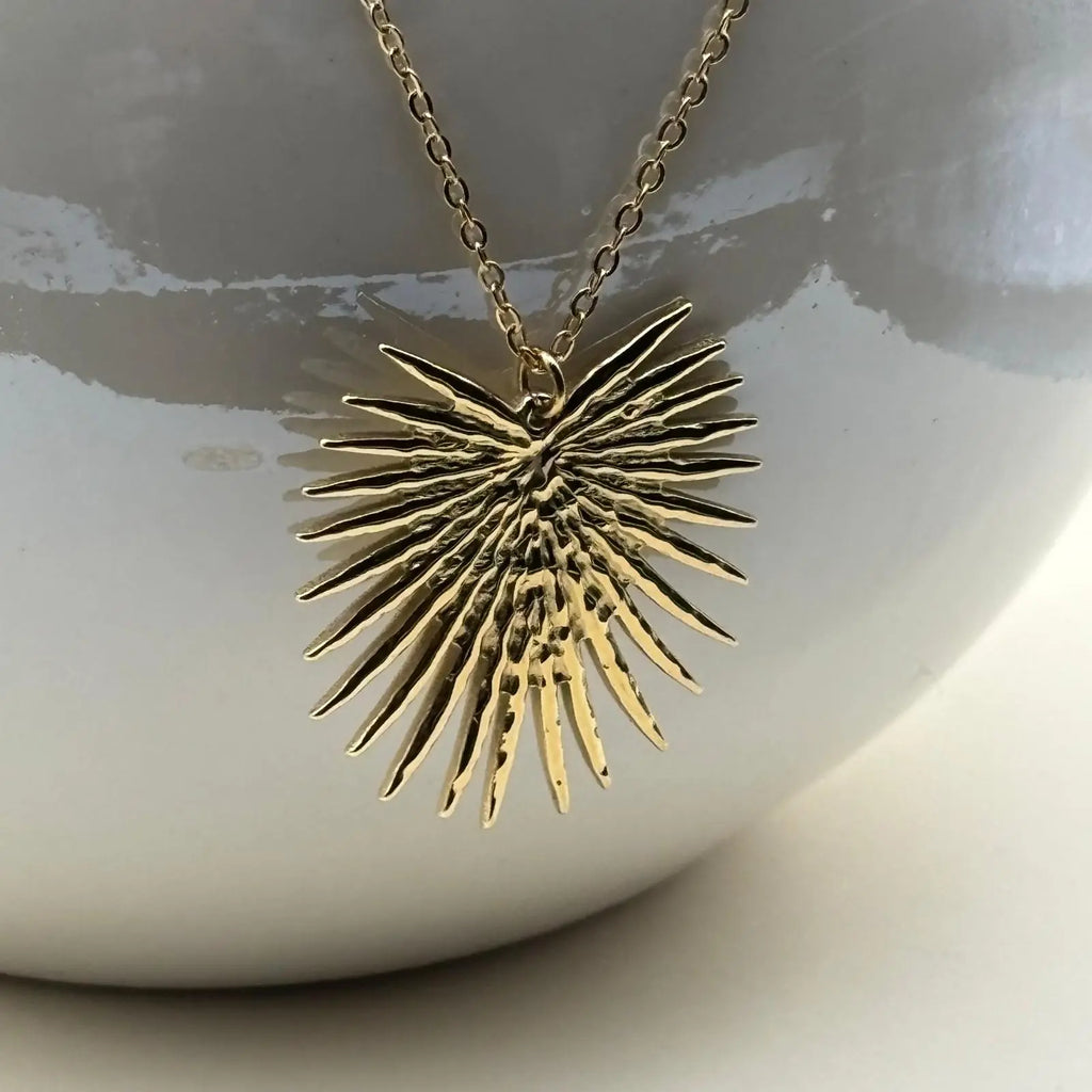 Collier et boucles d'oreilles de couleur dorée avec motif soleil éclatant