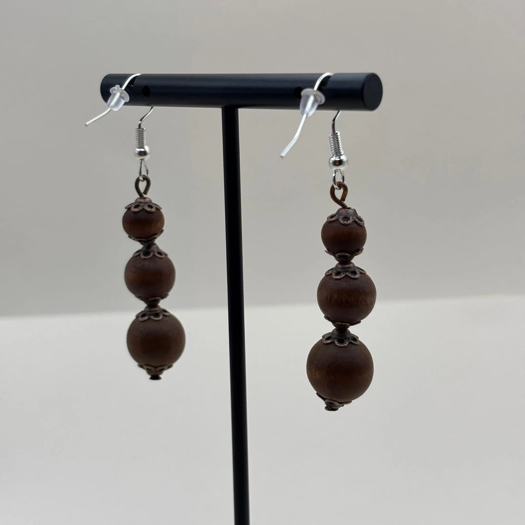 Une paire de boucles d'oreilles artisanales avec fixation argentées et trois perles marron