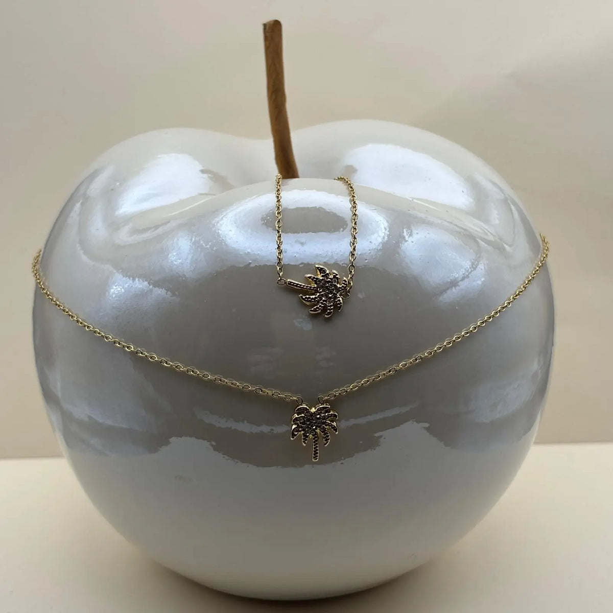 Collier doré et bracelet à petits maillons avec une breloque en forme de palmier avec des strass 