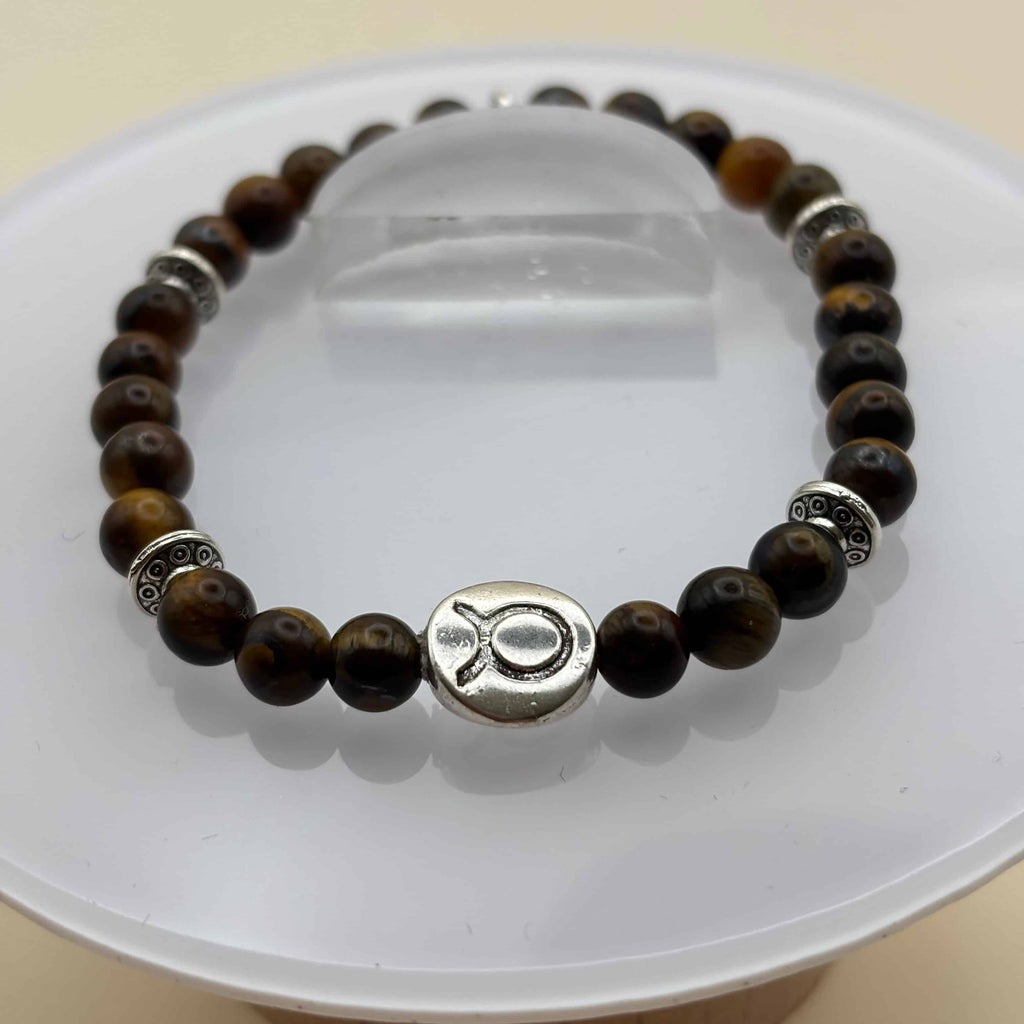 Un bracelet en perles sur élastique avec perles en porcelaine et en verre et médaillon avec le signe du taureau