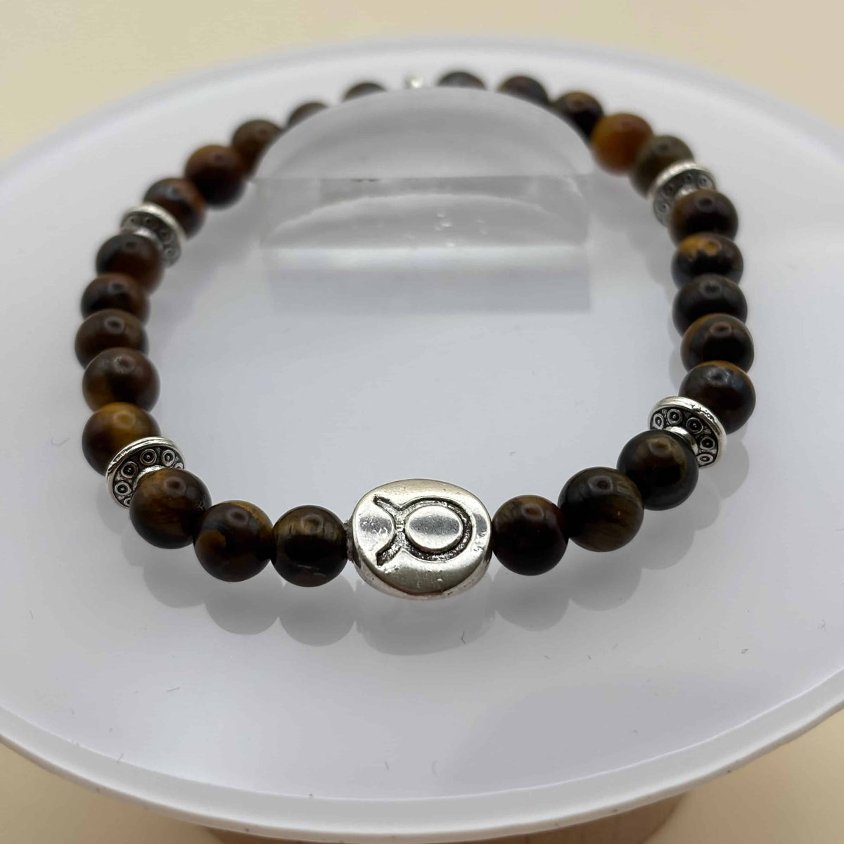 Un bracelet en perles sur élastique avec perles en porcelaine et en verre et médaillon avec le signe du taureau