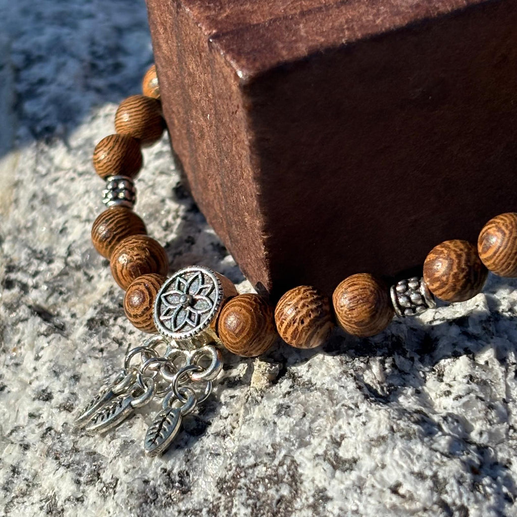 Vue de près d'un Bracelet en perles artisanal  avec breloque attrape rêve et perles en bois