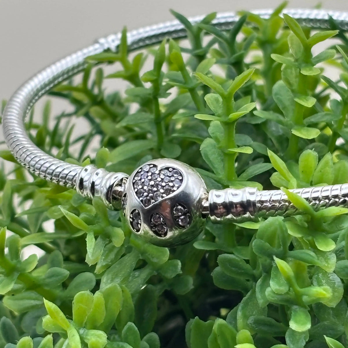 Un bracelet Pand'Or avec charm boule avec motif strass et cœur  en acier inoxydable