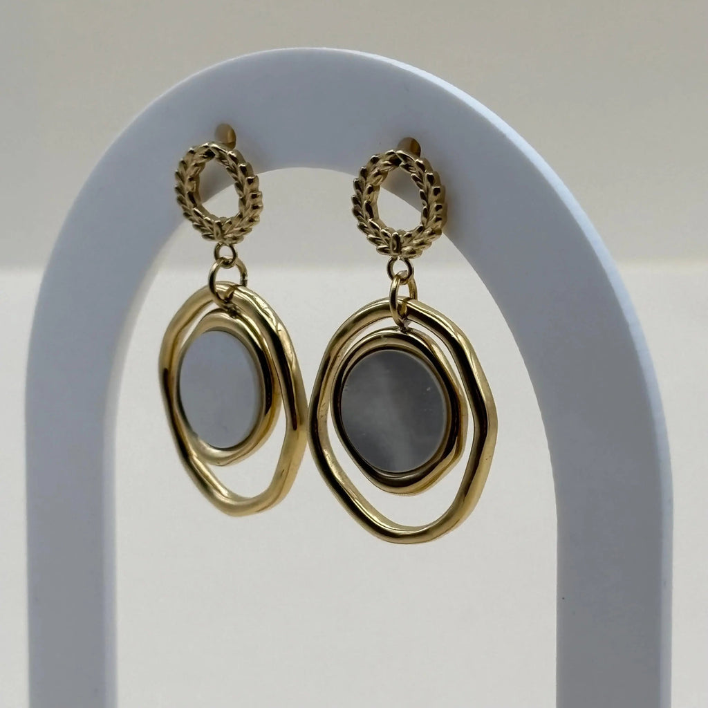 Des boucles d'oreilles dorées avec cercle ciselé doré et double cercle une perle de nacre c'est un bijou en acier inoxydable