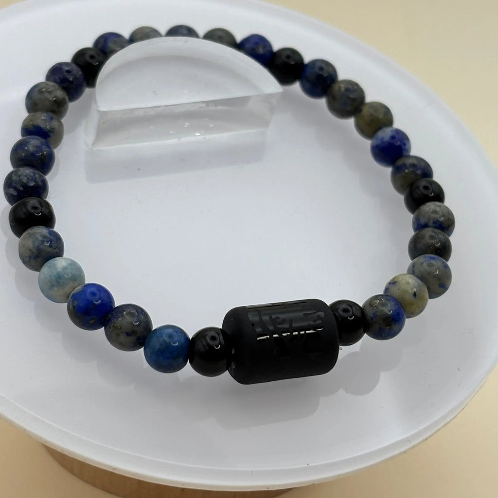 Bracelet aux perles mates brunes marbrées, agrémenté d’une perle centrale noire gravée