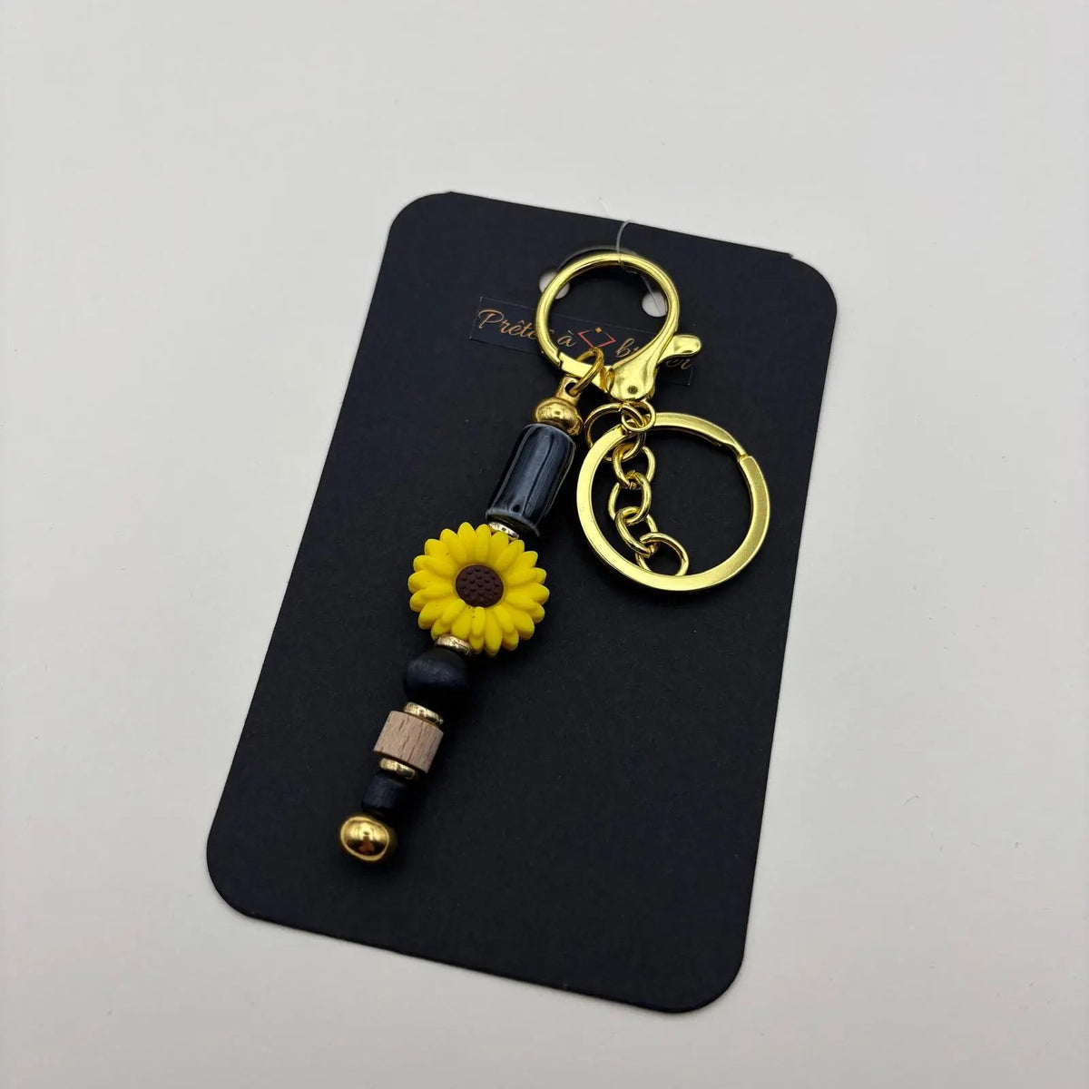 Porte clé doré en perles motif avec perles noir ronde et longues et fleur jaune