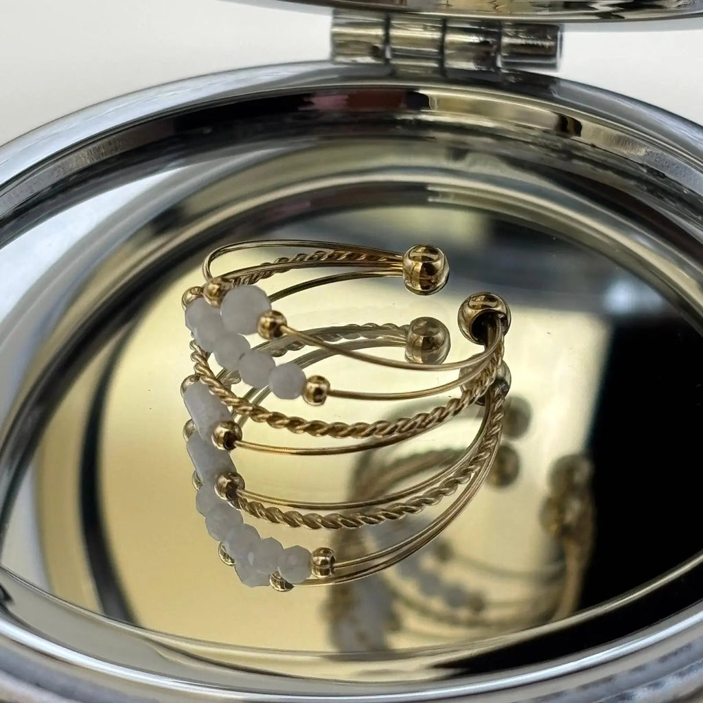 Bague dorée ajustable avec quatre fins anneaux et des perles blanches 