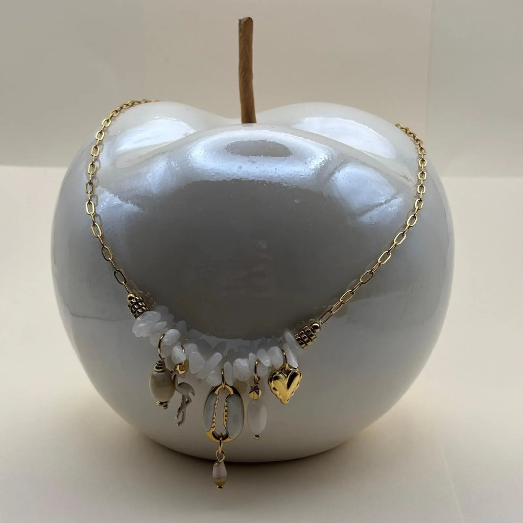 Un collier fantaisie avec une chaine dorée et des breloques cœur flamant blanc coquillages et perles blanches bijou en acier inoxydable