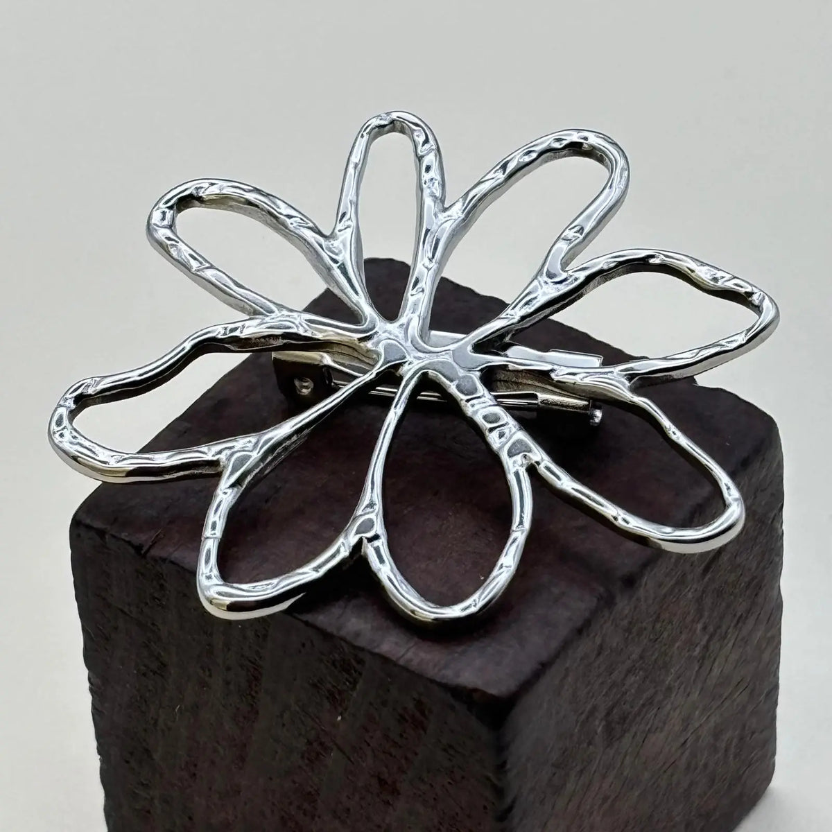 Broche argentée avec un motif pétales de fleurs