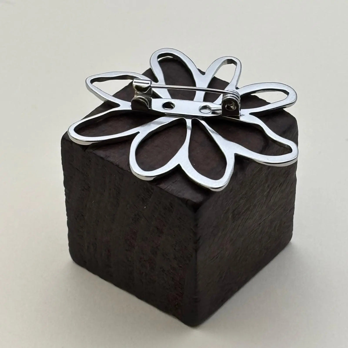 Broche de couleur argentée avec un motif pétales de fleurs