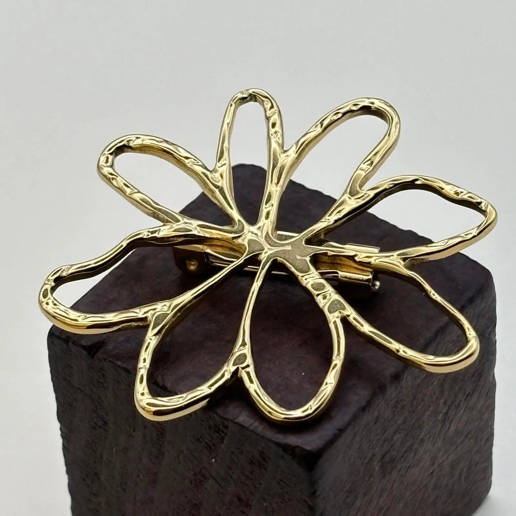 Broche dorée avec un motif pétales de fleurs