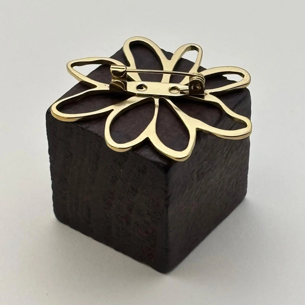 Broche de couleur dorée avec un motif pétales de fleurs