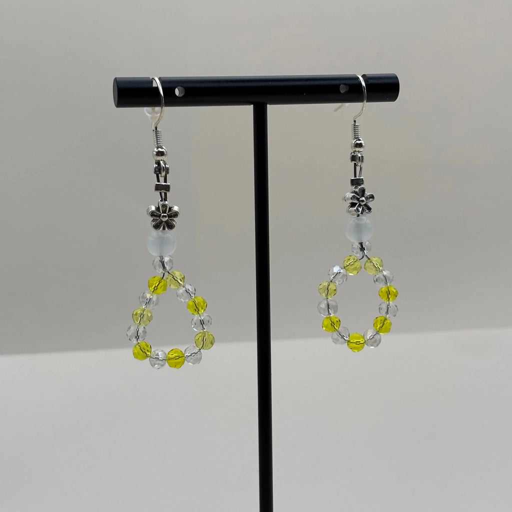 Boucles d'oreilles pendentif avec des perles acryliques blanches et une couronne en perles jaune et blanches