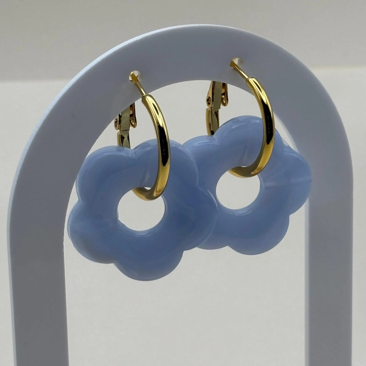 Boucles d'oreilles dorées façon créoles avec une fleur écrue bleue