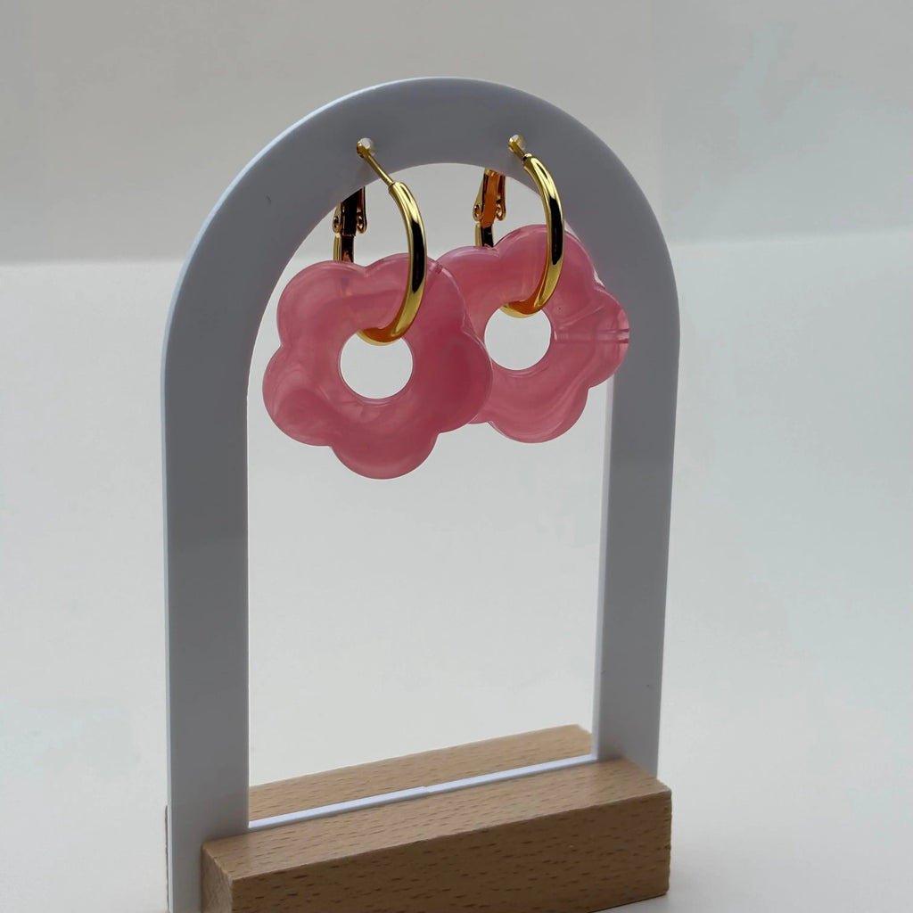 Boucles d'oreilles dorées façon créoles avec une fleur rose