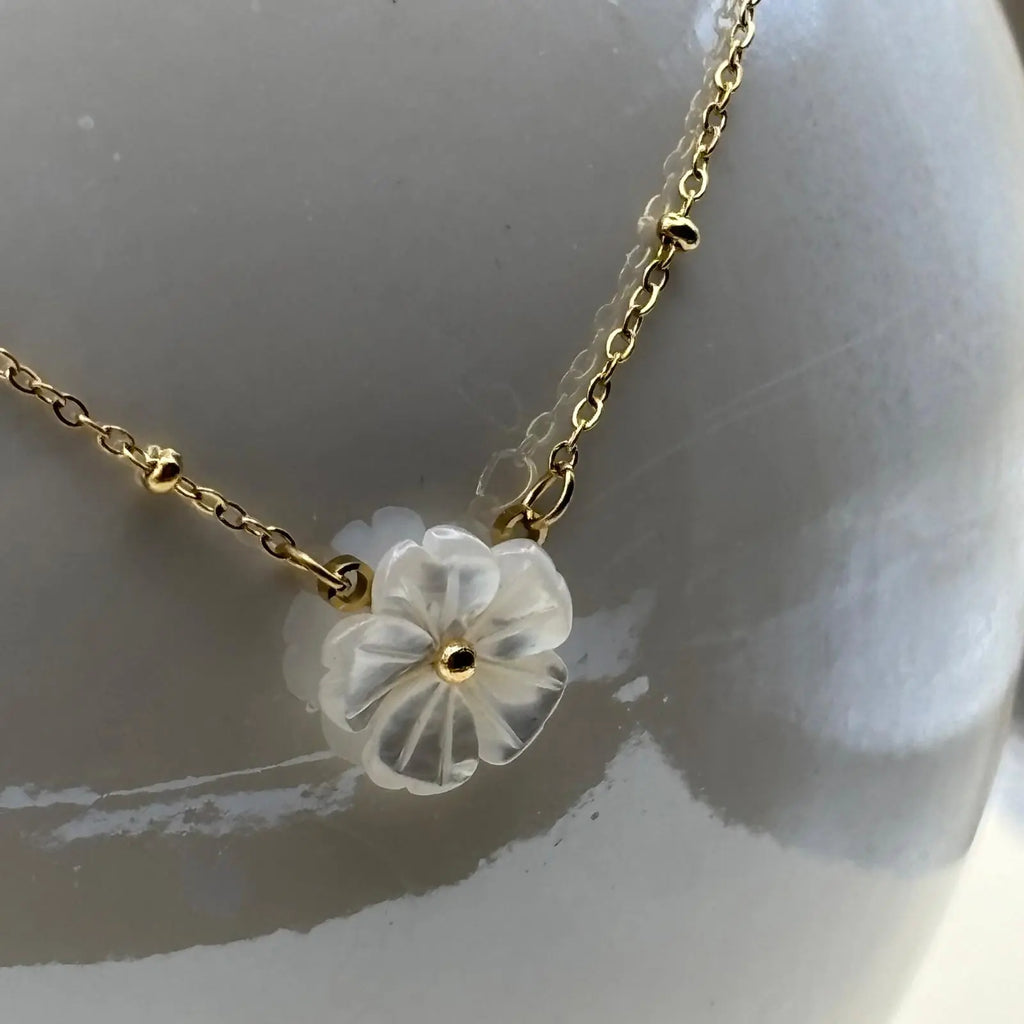 Collier à maillons fins dorées avec une breloque marguerite blanche et deux boucles d'oreilles marguerite