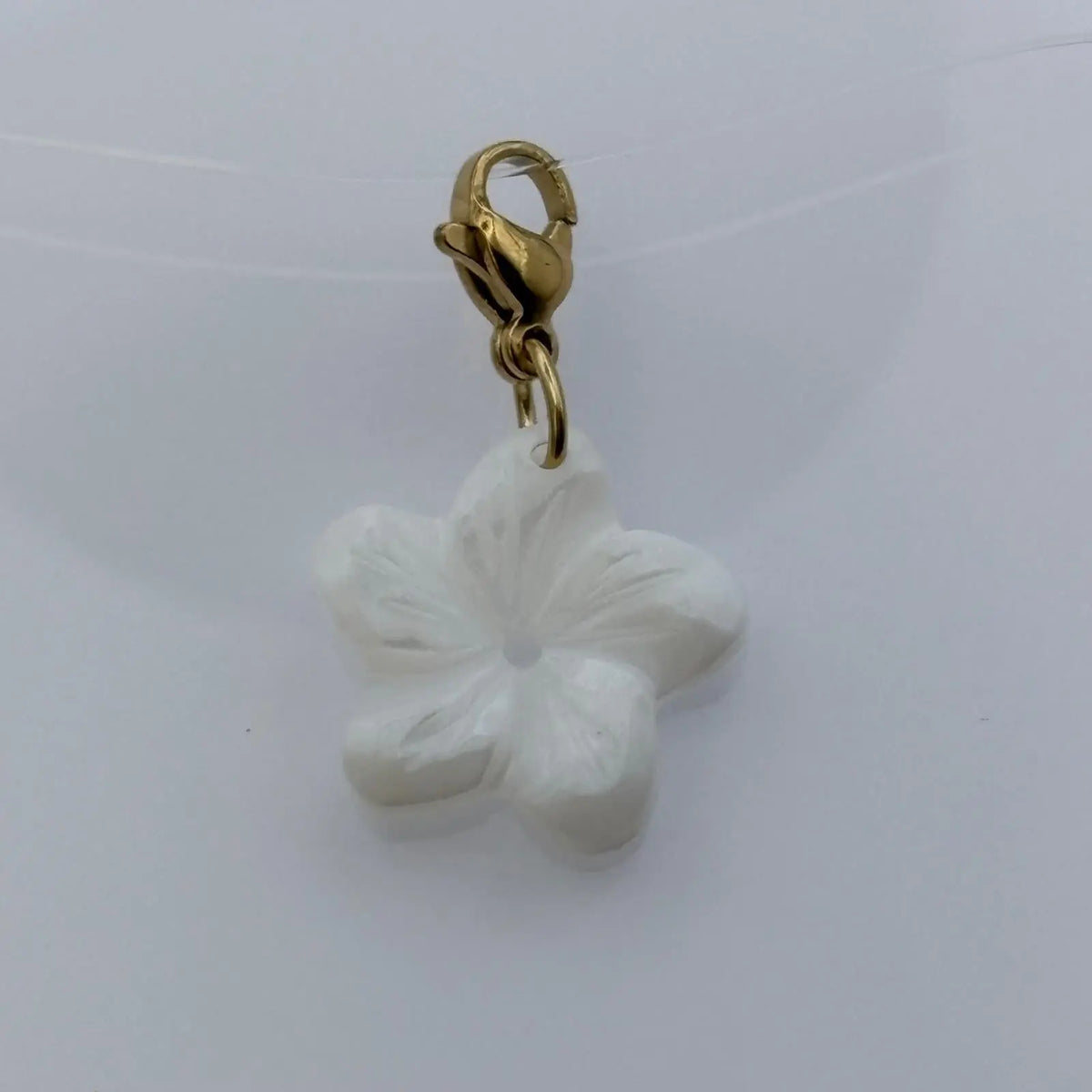 Bijou à accrocher doré avec fleur nacré 