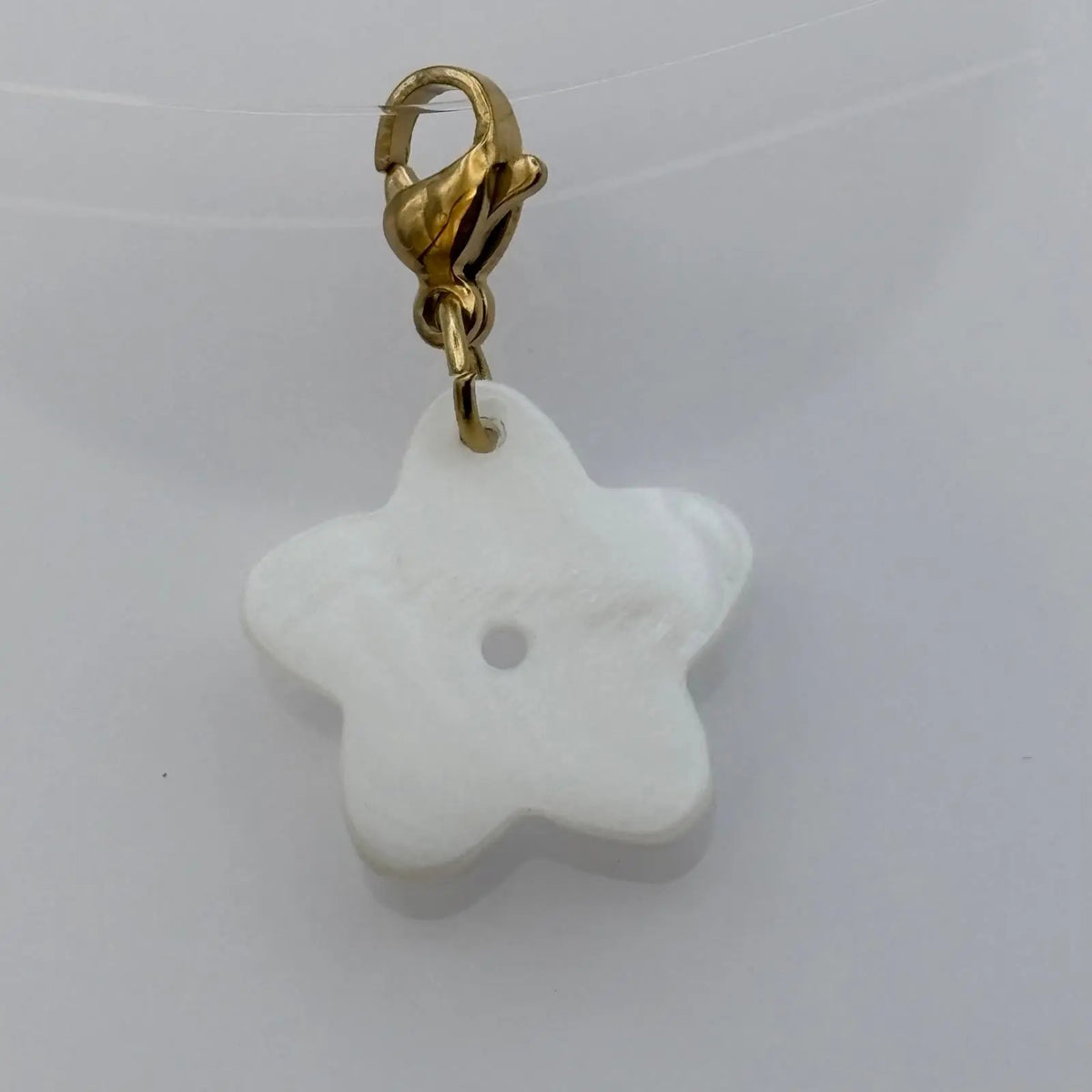 Bijou à accrocher de couleur dorée avec fleur nacré 