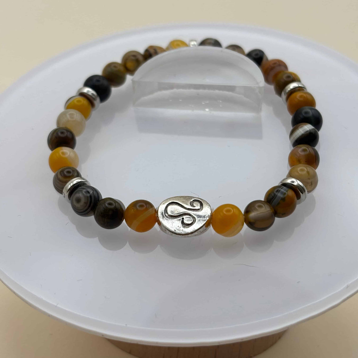 Un beau bracelet en perles sur élastique avec perles en porcelaine et en verre et médaillon avec le signe zodiacal du lion